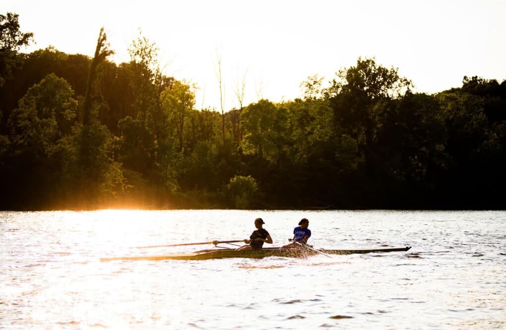 Two rowers rowing on the grand river at sunrise